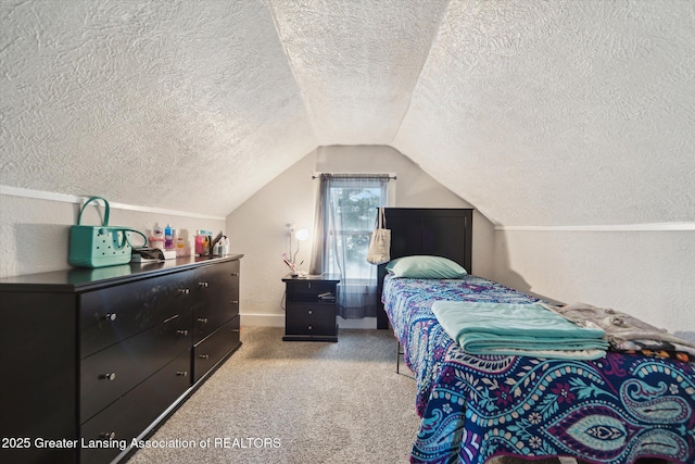 bedroom featuring a textured wall, light colored carpet, vaulted ceiling, and a textured ceiling