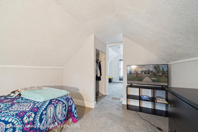 carpeted bedroom featuring baseboards, visible vents, a textured wall, lofted ceiling, and a textured ceiling