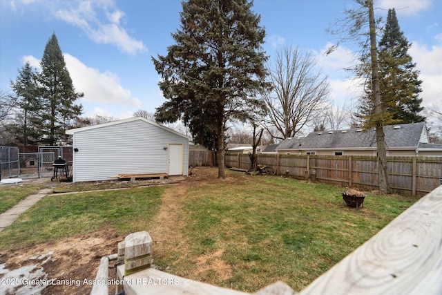 view of yard with a gate, a fenced backyard, and an outdoor structure