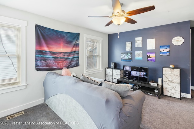 living area featuring a ceiling fan, carpet, visible vents, and baseboards