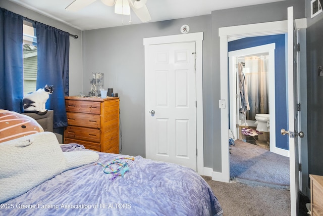 carpeted bedroom featuring visible vents, ceiling fan, baseboards, and ensuite bathroom