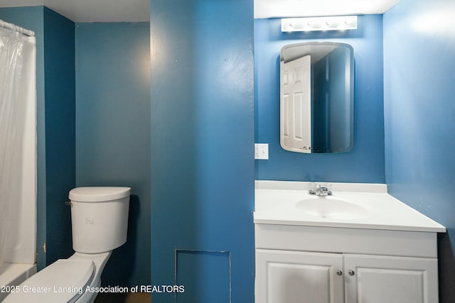 bathroom featuring toilet, a shower with shower curtain, and vanity