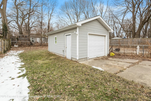 detached garage with fence and concrete driveway