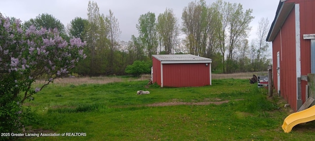 11173 W Bennett Rd, Sumner, MI 48889 - view of green lawn with an outbuilding, a storage unit, and a playground