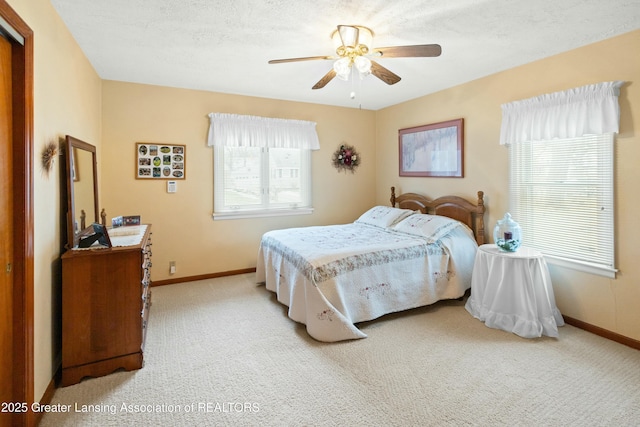 carpeted bedroom featuring a ceiling fan, a textured ceiling, and baseboards