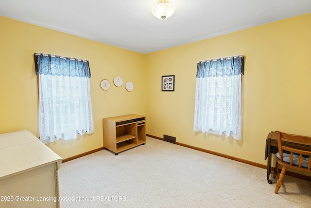 bedroom featuring multiple windows, light colored carpet, and baseboards