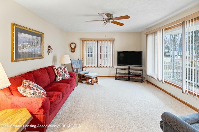 living room with carpet floors, ceiling fan, a textured ceiling, and baseboards