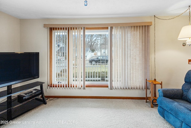 living area featuring carpet flooring and baseboards