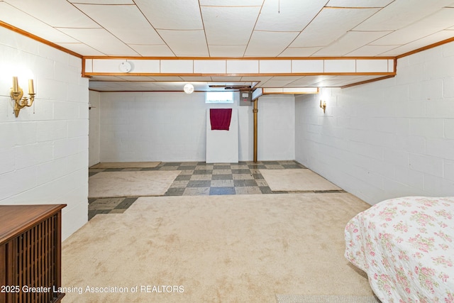 below grade area featuring carpet flooring and concrete block wall