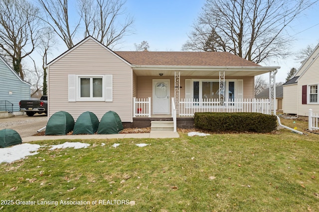 bungalow-style home featuring a shingled roof, a porch, and a front yard