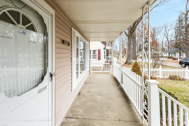 view of patio featuring covered porch and fence