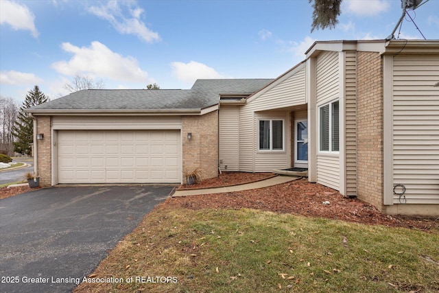 view of front of home with an attached garage, a shingled roof, aphalt driveway, and brick siding