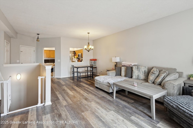 living area featuring a chandelier, baseboards, and wood finished floors