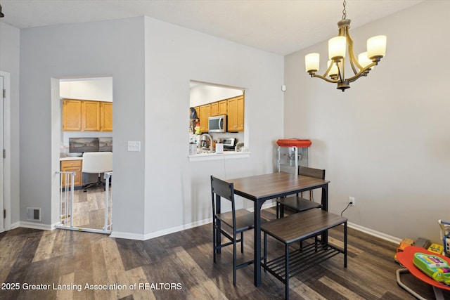 dining room with a notable chandelier, dark wood finished floors, visible vents, and baseboards