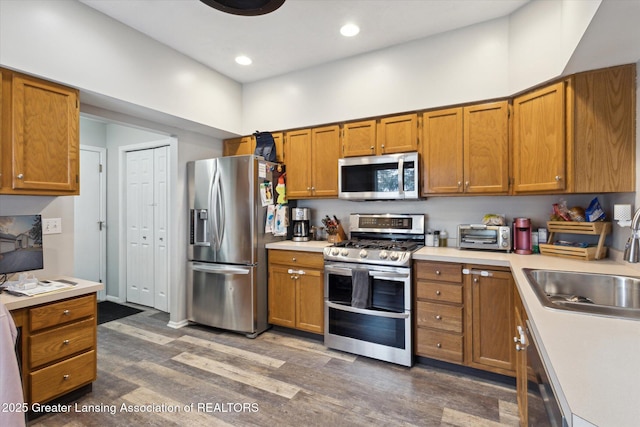 kitchen featuring dark wood finished floors, stainless steel appliances, and light countertops