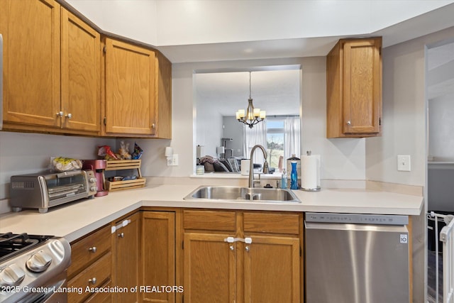 kitchen featuring a toaster, a notable chandelier, a sink, light countertops, and appliances with stainless steel finishes