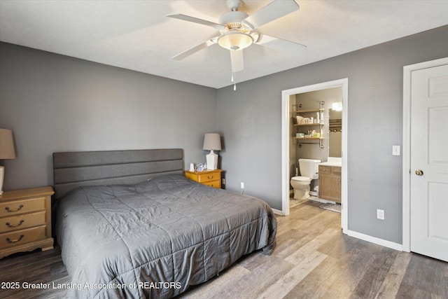 bedroom featuring ensuite bathroom, ceiling fan, baseboards, and wood finished floors