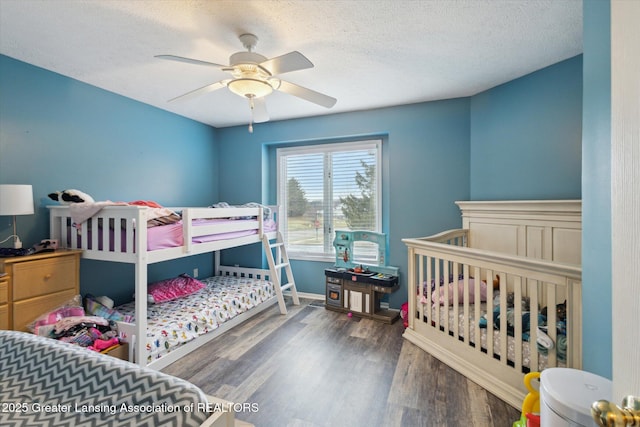 bedroom with a ceiling fan, a textured ceiling, baseboards, and wood finished floors