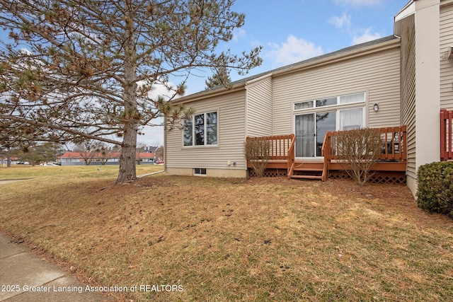 back of house with a deck and a lawn