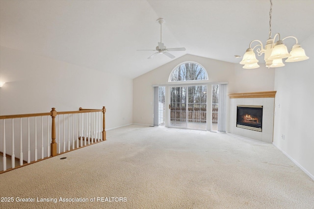 unfurnished living room featuring baseboards, carpet floors, a fireplace, high vaulted ceiling, and ceiling fan with notable chandelier