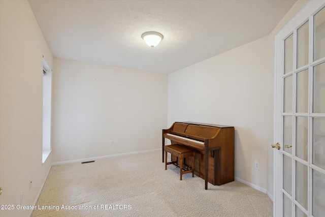 interior space featuring carpet floors, visible vents, and baseboards