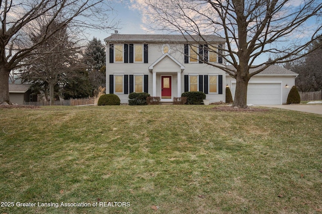 colonial house featuring concrete driveway, fence, a front lawn, and an attached garage