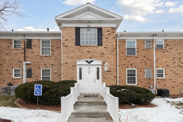 view of front of house featuring brick siding and cooling unit