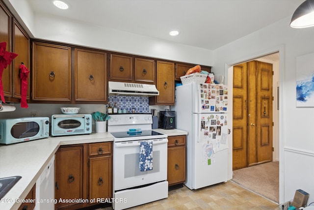 kitchen with brown cabinets, range hood, white appliances, and light countertops