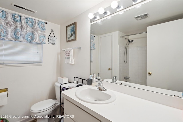 bathroom with visible vents, vanity, toilet, and walk in shower