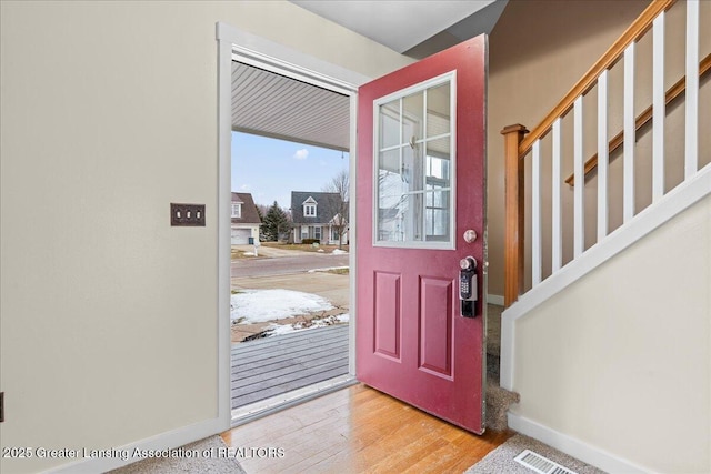 foyer featuring stairs, wood finished floors, visible vents, and baseboards