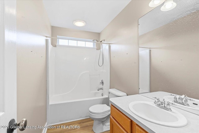 full bath featuring wood finished floors, vanity, toilet, and shower / bathing tub combination