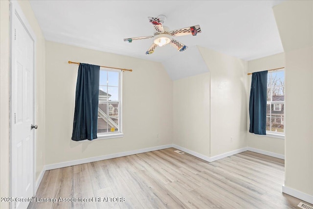 unfurnished bedroom featuring lofted ceiling, ceiling fan, wood finished floors, visible vents, and baseboards