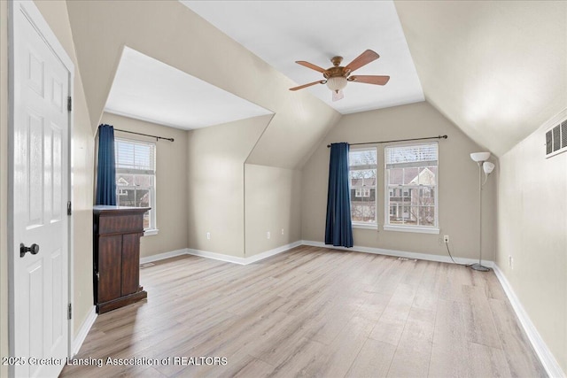 bonus room featuring light wood-style floors, plenty of natural light, baseboards, and vaulted ceiling