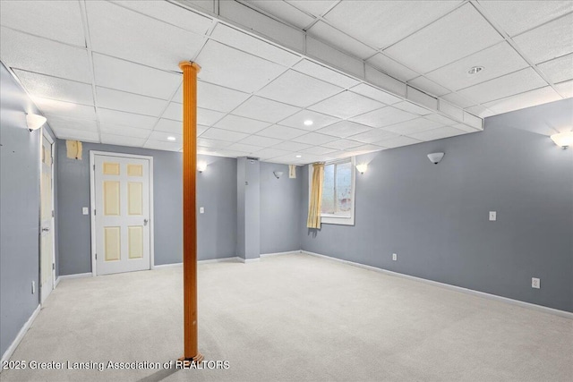 finished basement with carpet flooring, a drop ceiling, and baseboards