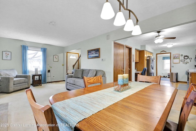 dining room featuring stairs, a ceiling fan, and baseboards