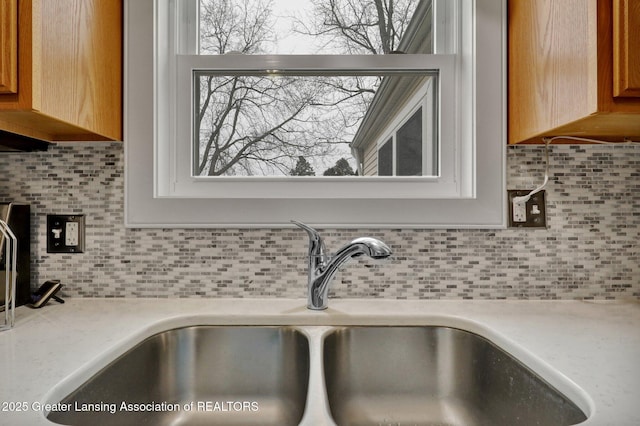 room details with tasteful backsplash, light countertops, and a sink