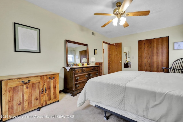 bedroom featuring ceiling fan, visible vents, and light colored carpet