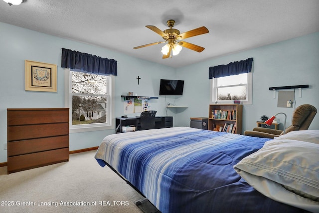 carpeted bedroom with a ceiling fan, baseboards, and a textured ceiling