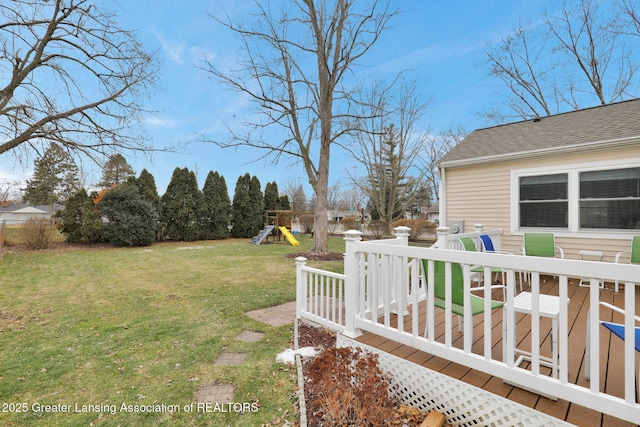 view of yard featuring fence, a playground, and a wooden deck