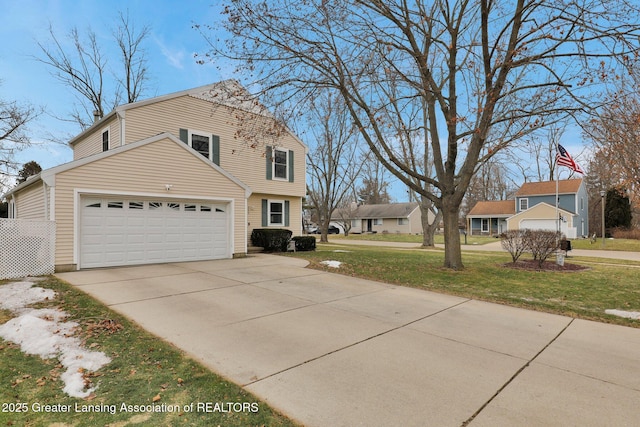 view of front of house featuring a front yard, concrete driveway, and an attached garage