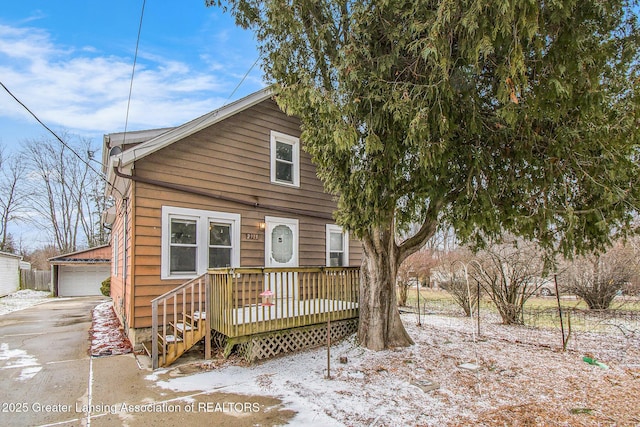 view of front of home featuring a detached garage, an outdoor structure, and a wooden deck