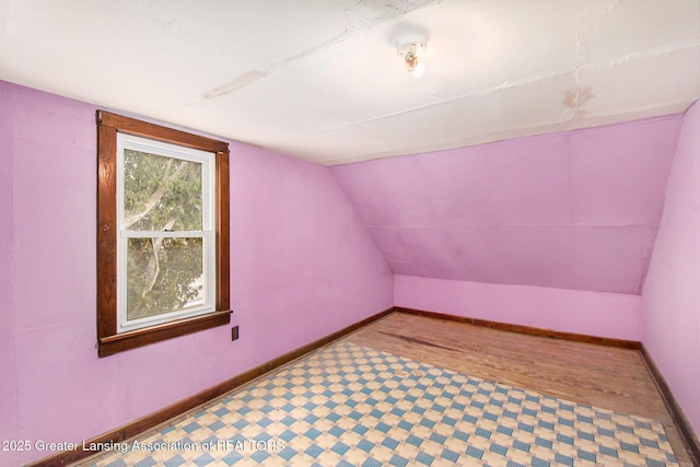 bonus room with baseboards and vaulted ceiling