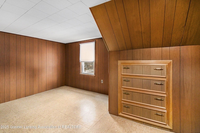 additional living space with wood walls and tile patterned floors