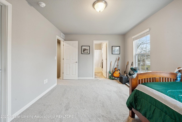 bedroom with carpet, baseboards, and ensuite bathroom