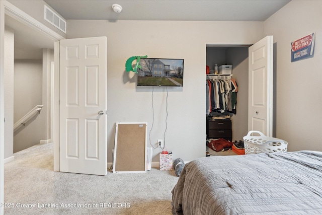 carpeted bedroom featuring a spacious closet, visible vents, and a closet