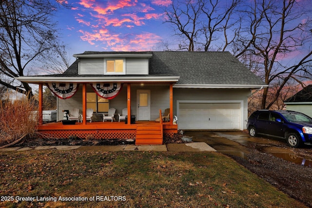 view of front of property with an attached garage, covered porch, driveway, and a shingled roof