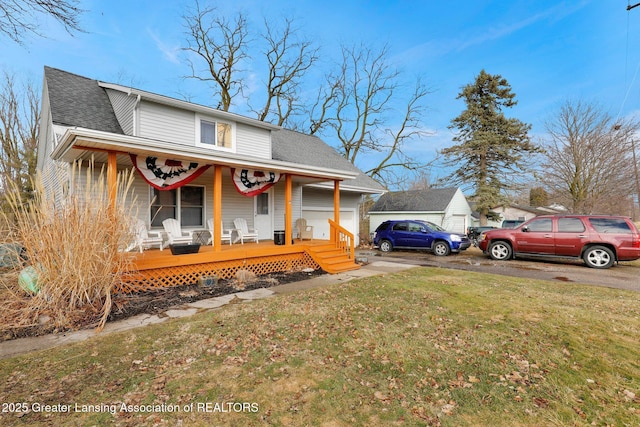 view of front of home with covered porch, roof with shingles, and a front lawn