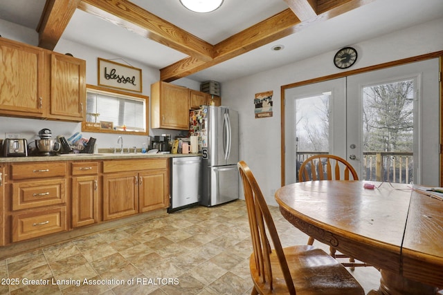 kitchen featuring stainless steel appliances, french doors, a sink, and beam ceiling