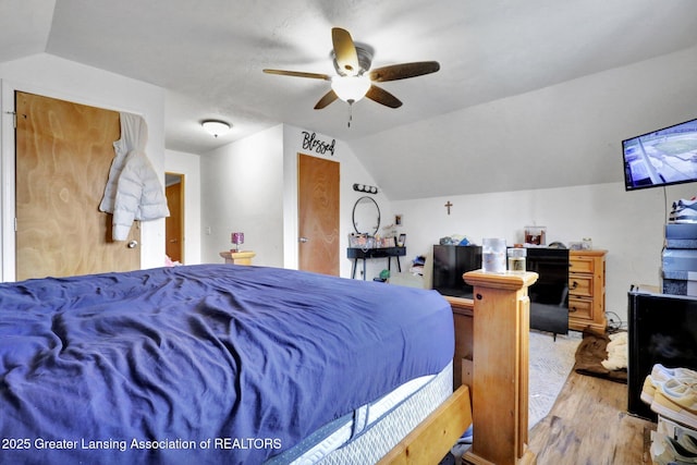 bedroom featuring ceiling fan, vaulted ceiling, and wood finished floors