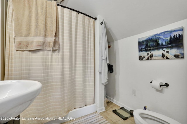 full bath featuring toilet, a shower with curtain, tile patterned flooring, and a sink